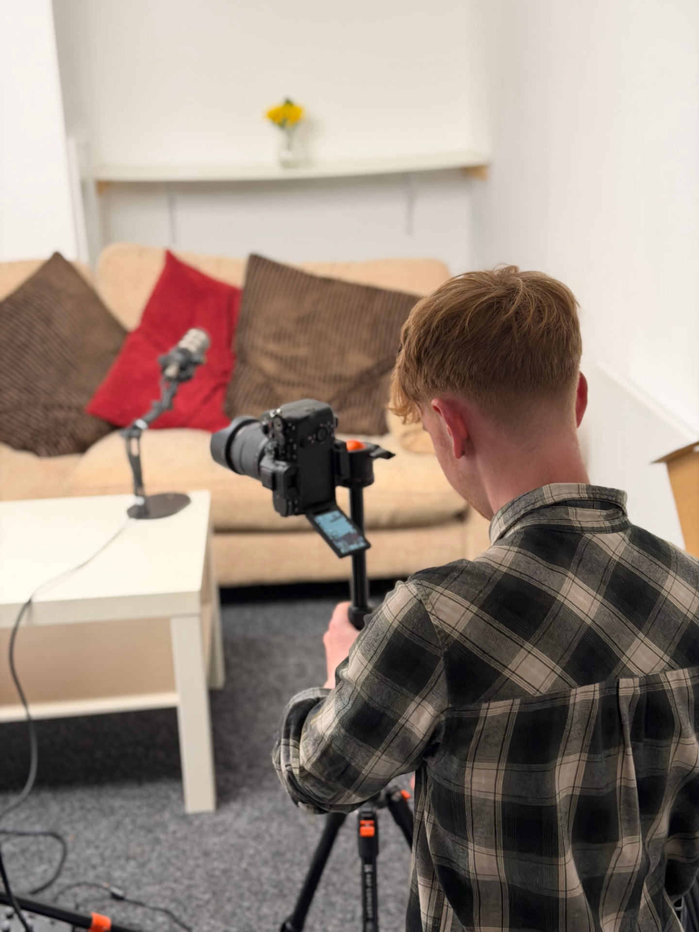 The Studio at River House: a team member behind the camera reviewing files during a session, with the recording set ready